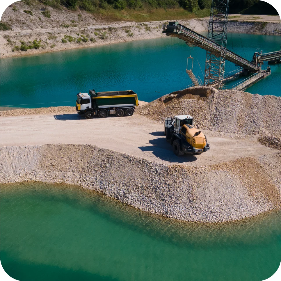 Tipper trucks working in a quarry beside a lake